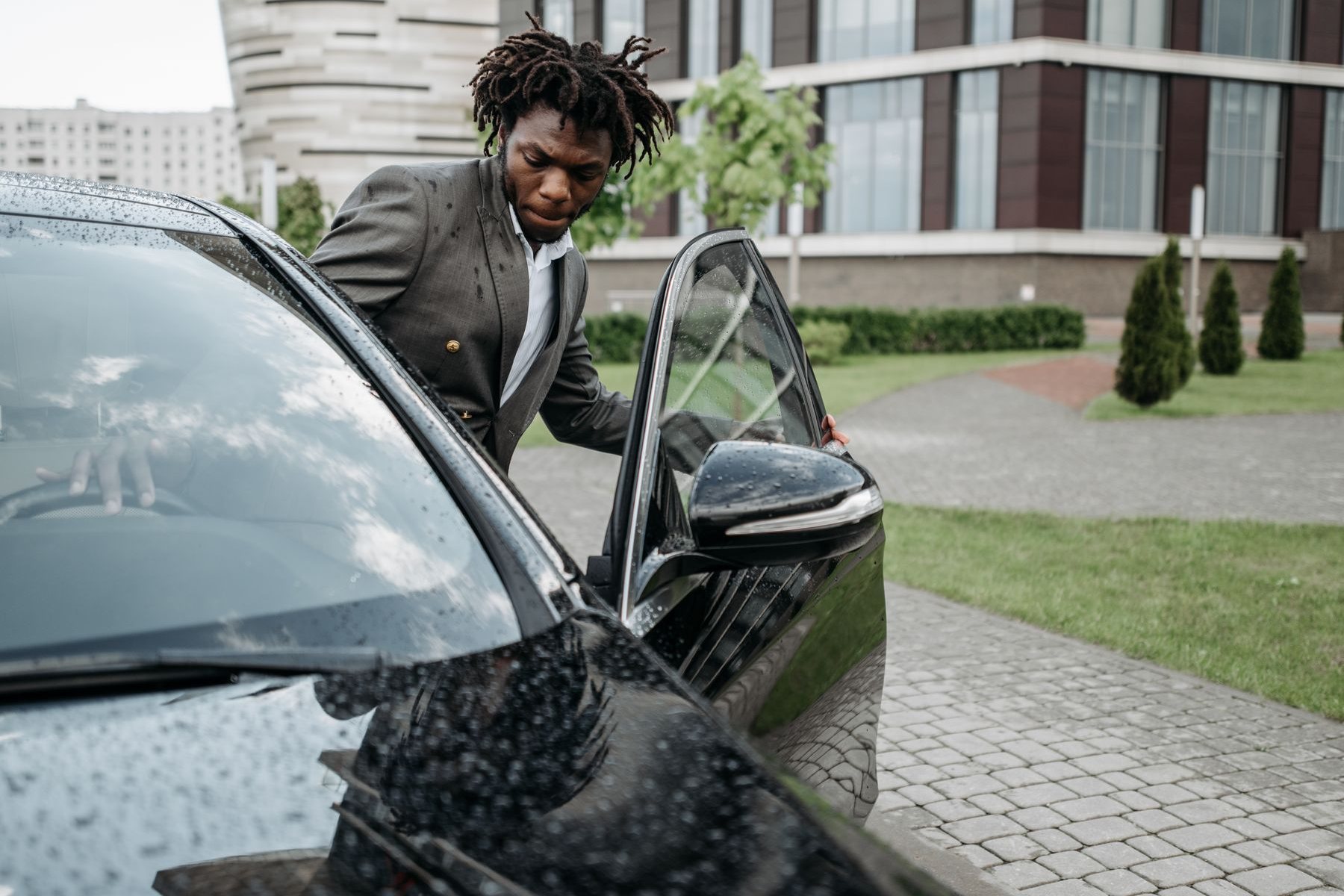A claims assessor in a grey suit inspects a car